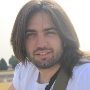 foto de un hombre con pelo largo y barba sonriendo