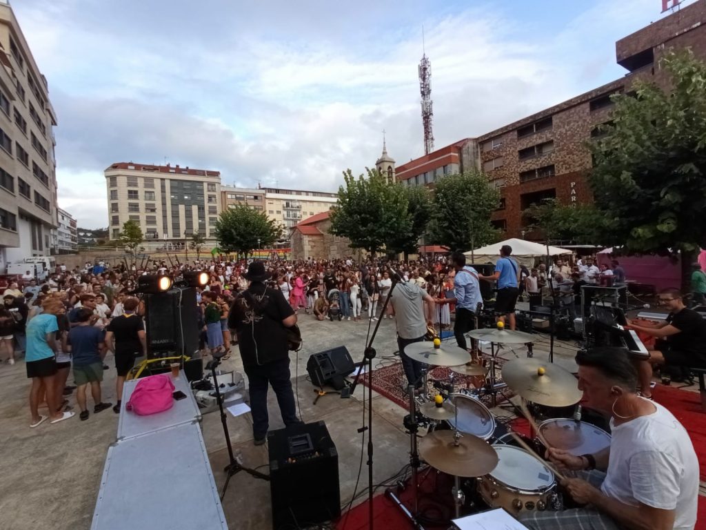 Una banda tocando música frente a una audiencia al aire libre